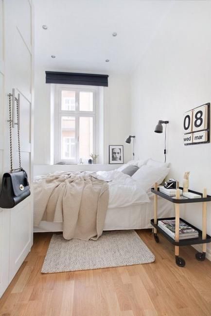 a bedroom with white walls and wooden floors