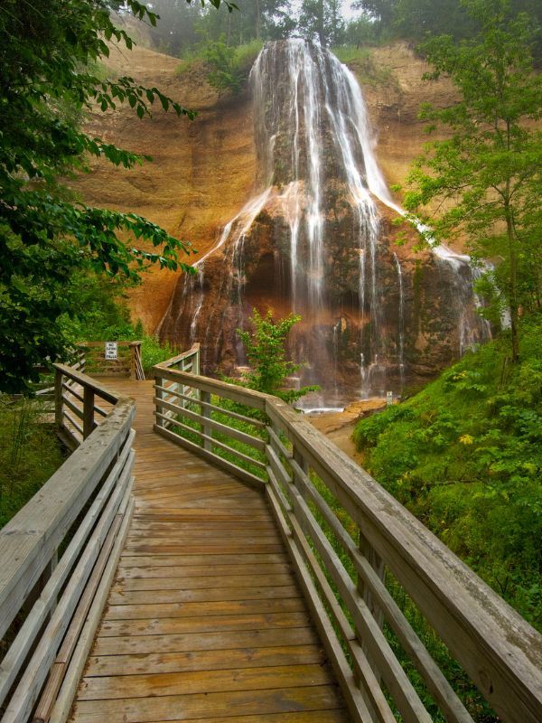 a wooden walkway leading to a waterfall