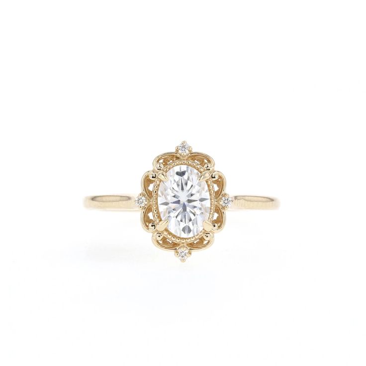 a yellow gold engagement ring with an oval cut diamond in the center, surrounded by small diamonds