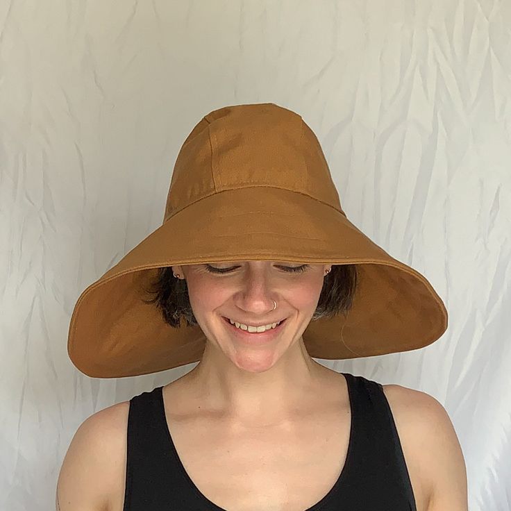 "Say hello to the sun hat of your dreams!  The oversized brim - made from a beautifully neutral Carhartt Brown canvas - protects your face and neck from the sun.  The inner crown is lined with the lightest, softest SWEAT WICKING technical fabric.  This hat is fully foldable, packable, mushable--take it anywhere! Specifications:  100% Cotton Canvas Outer  Polyester Moisture Wicking Liner Nylon Cordura Interfacing Measurements: Size Small head size 22\" (56 cm) Size Medium head size 23\" (58 cm) Size Large  head size 24\" (61 cm)" Brown Uv Protection Bucket Hat, Solid Color Curved Brim Hats For Warm Weather, Brown Brimmed Hat With Uv Protection, Brown Brimmed Bucket Hat With Upf 50+, Solid Color Brimmed Hat For Warm Weather, One Size Fits Most Sun Hats For Warm Weather, Brown Sun Hat With Uv Protection, Warm Weather Sun Hats One Size, Brown Bucket Hat With Upf 50+ And Short Brim