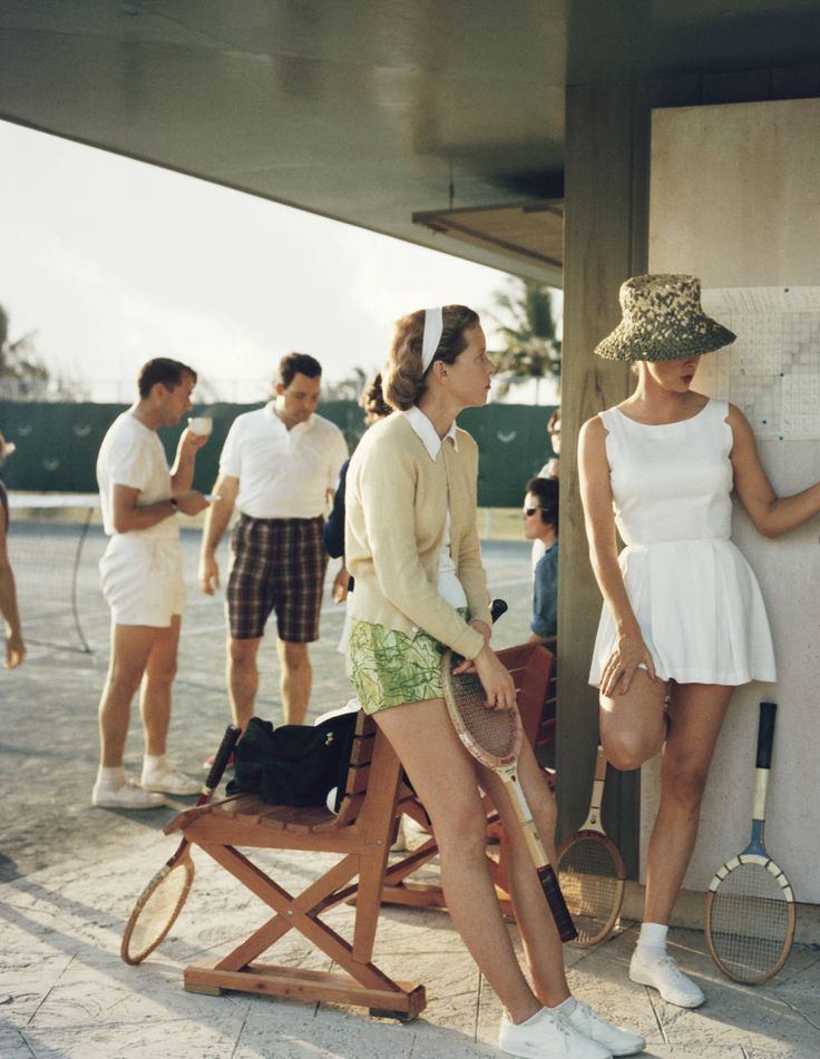 several people standing around in front of a wall