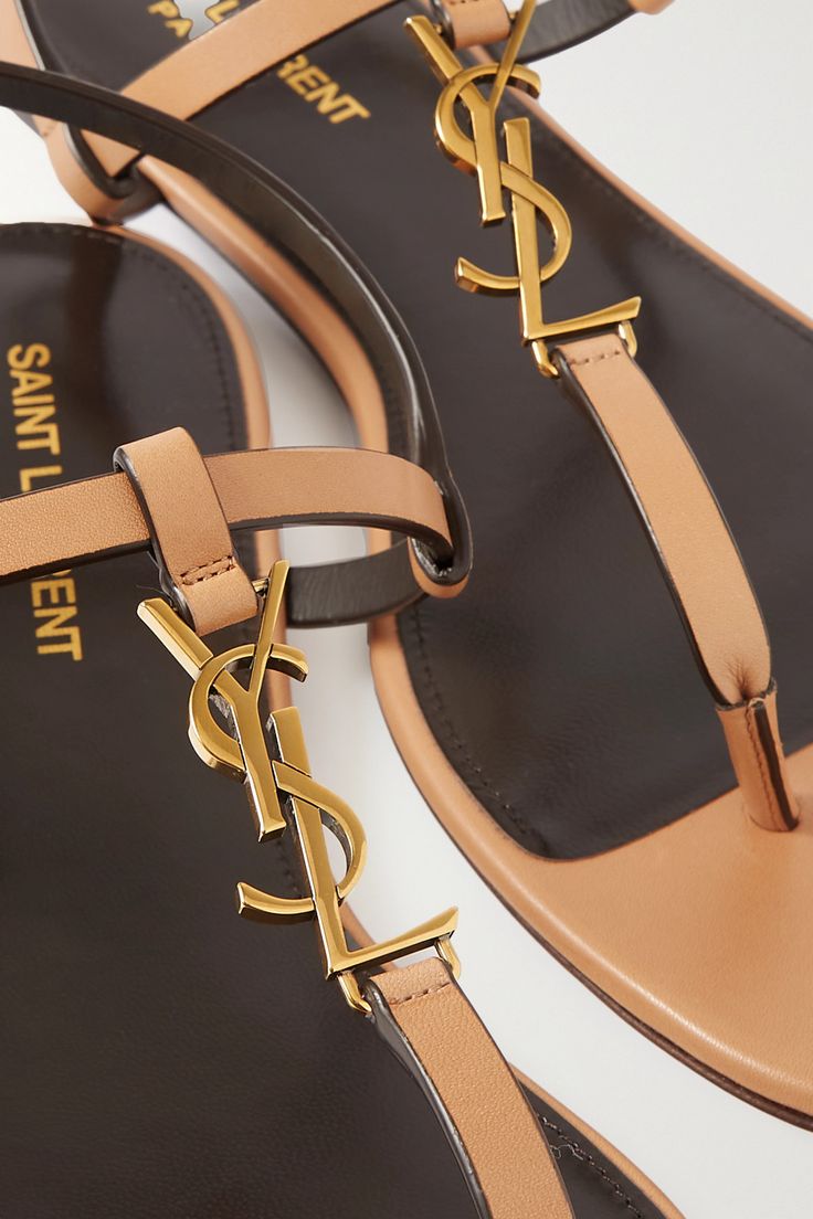 Find SAINT LAURENT Cassandra Logo-embellished Leather Slingback Sandals on Editorialist. SAINT LAURENT's 'Cassandra' sandals gleam with the brand's iconic 'YSL' monogram They're made from leather with slingback straps and thong toe posts. Match your other accessories to the gold hardware. Ss23 Fashion, Designer Flat Sandals, Fancy Heels, Ysl Sandals, Latest Sandal, Ysl Heels, Heels Sneakers, Designer Pieces, Clothing Outfits