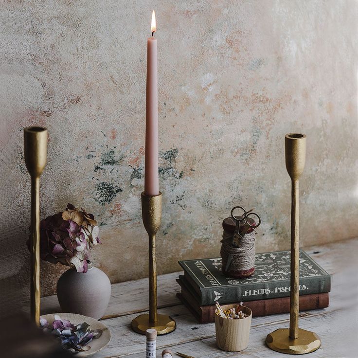 three candles and two vases on a table