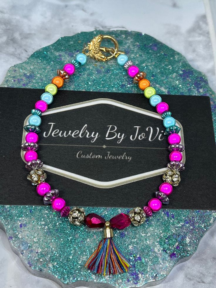 If you love bright colors, you'll love this beautiful, bright toggle bracelet. This bracelet is made with various, colorful Jesse James beads, & it's finished off with a beautiful little tassel. The beads are so bright & absolutely stunning, & pics definitely don't do this bracelet justice! The beads have such a lovely glow😍.  8 inches in length with toggle clasp. Multicolor Bohemian Charm Bracelet For Friendship, Bohemian Multicolor Charm Bracelet For Friendship, Bohemian Rainbow Bracelets With 8mm Beads, Bohemian Purple Bracelets With Heart Beads, Multicolor Round Bead Friendship Jewelry, Bohemian Multicolor Beaded Bracelets With Heart Beads, Multicolor Bohemian Crystal Bracelet As Gift, Bohemian Multicolor Crystal Bracelet As Gift, Bohemian Multicolor Crystal Bracelet Gift