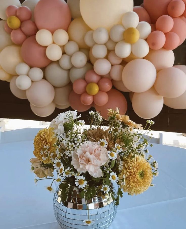 a vase filled with flowers sitting on top of a white table cloth covered tablecloth