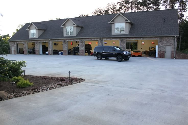 a black truck parked in front of a large building with two garages on each side