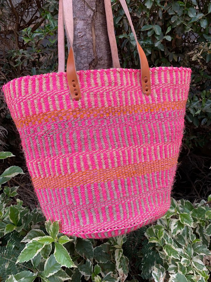 "Etra Large Kiondo shopping bag,round base sisal bag, storage bag, Home organizing bag,Sisal kiondo basket, Pink and purple kiondo bag. The color bag is great for your day out shopping or at the beach. Can also be used for your home organization and storage. Dimensions Top 30\" Height 13.5\" Base lenght 20\"x 13.5\" wide Ready to ship Thank you so much for shopping with us!" Pink Bucket Bag With Braided Handles In Tote Shape, Pink Tote Bucket Bag With Braided Handles, Pink Bucket Bag With Braided Handles, Pink Handwoven Bucket Bag For The Beach, Pink Rectangular Beach Bag For Travel, Casual Pink Rectangular Bucket Bag, Pink Shoulder Bucket Bag With Braided Handles, Pink Handwoven Bucket Bag For Travel, Pink Handwoven Travel Bucket Bag