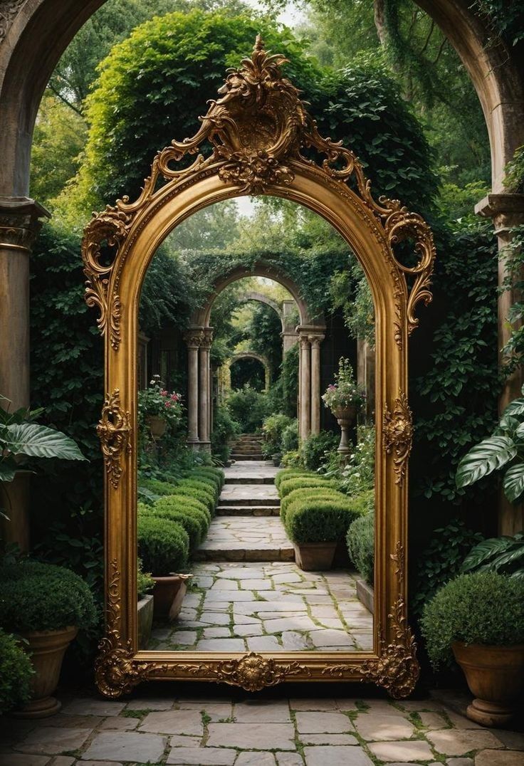 an ornate gold framed mirror sitting on top of a stone walkway surrounded by greenery