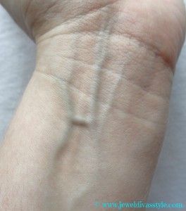 a person's arm with a small cross on the left side of their arm