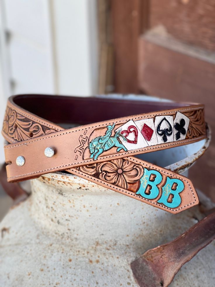 a brown belt with blue letters and playing cards on the side, sitting on top of a pot