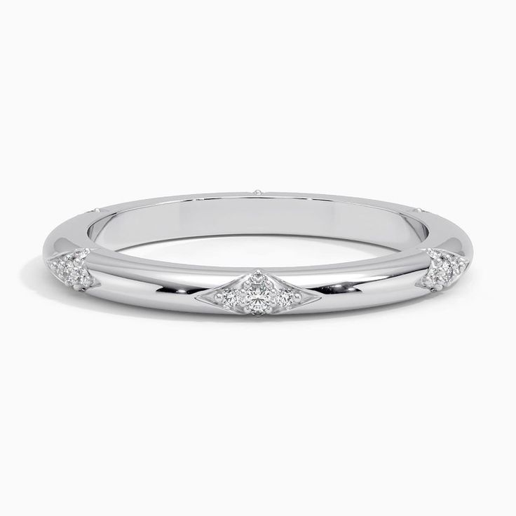 a white gold wedding band with three princess cut diamonds on the top and side stones