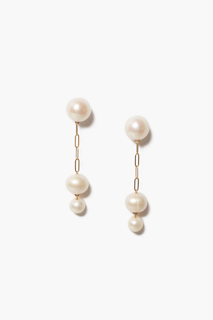 A modern take on the classic pearl, these 18k gold plated sterling silver drop earrings feature two petite graduated freshwater pearls hanging from a paperclip chain with pearl post. A timeless design perfect on its own or paired with dainty earrings.18k gold plated sterling silver.2" drop.Handmade in Vietnam. Unique Pearl Earrings, Unique Handmade Earrings, Freshwater Pearl Drop Earrings, Hammered Hoop Earrings, Semi Precious Gems, Sterling Silver Drop Earrings, Statement Drop Earrings, Pearl Design, Earrings White