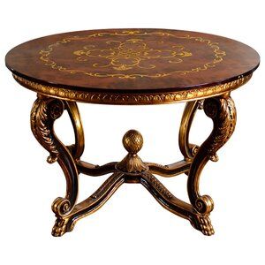 an ornately decorated table with gold leaf designs on the top and bottom, against a white background