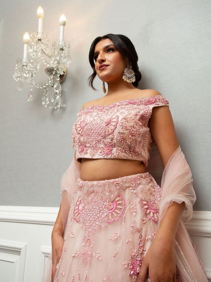 Farah Lehenga is a beautiful ensemble in an eternal blush pink, elevating the bride's attire. The scrupulous embroidery and glint of mirrors and resplendent pearls and glittering stone make it classy and sumptuous. Stitched with soft net fabric, it is inclusive of embroidered dupatta and blouse and lehenga that gives an ultimate, refined and royal look to the bride-to-be at her special occasion. Ideal for weddings and other exclusive events. Key Features: Color: Blush Pink Fabric: Soft net Embel Pink Lehenga Blouse, Blush Pink Lehenga, Buy Lehenga Online, Blush Pink Fabric, Indian Bridal Couture, Elegant Veils, Reception Gowns, Blouse Lehenga, Thread Beads