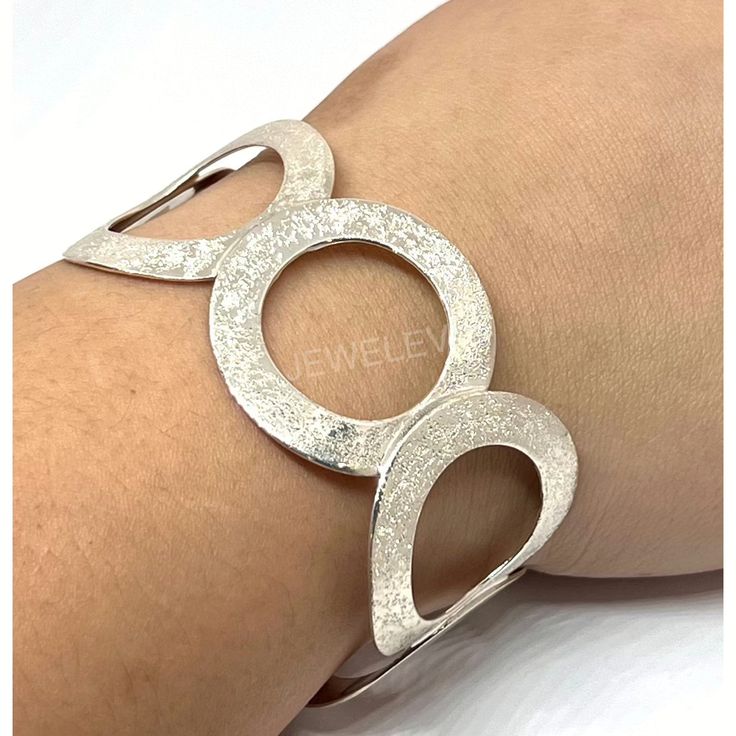 A classic, timeless design with a modern twist. This sparkly sterling silver cuff bracelet features a boldly circled cuff design that glistens in the light. Crafted with care and a passion for quality, this accessory will add a touch of style to any look. Make a statement with this Cuff!