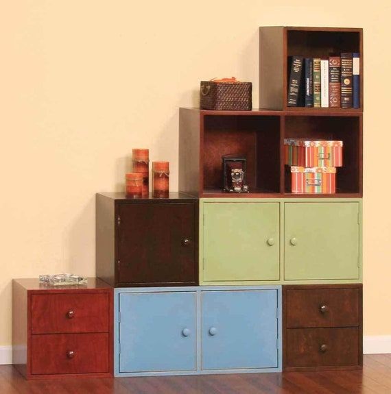 the bookshelf is made out of different colored boxes and drawers, which are stacked on top of each other