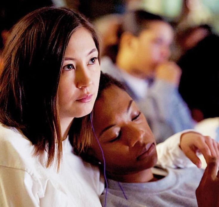 two women sitting next to each other with headphones on