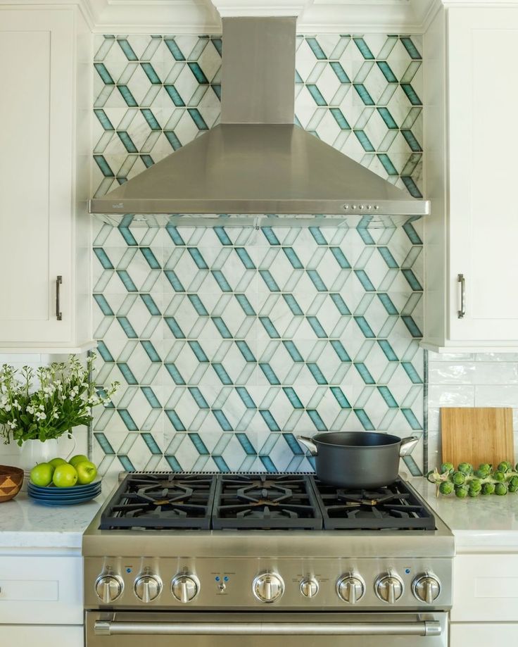 a stove top oven sitting inside of a kitchen next to white cabinets and counter tops