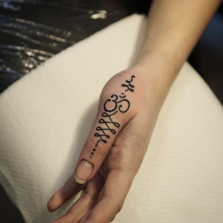 a person with a tattoo on their left hand