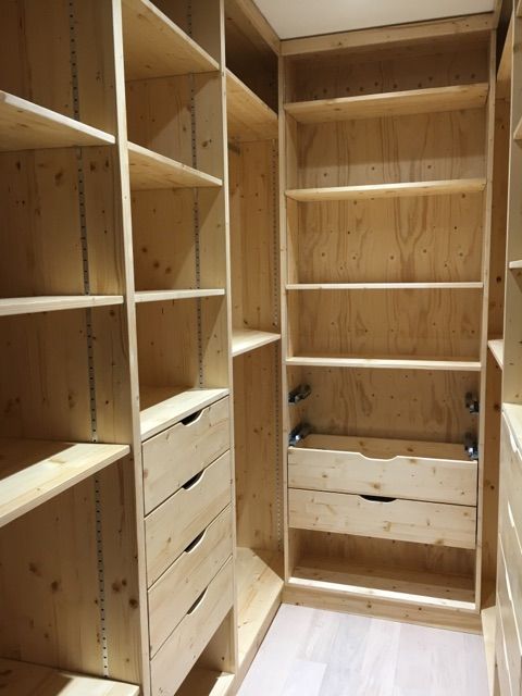 an empty walk in closet filled with lots of wooden shelves and drawers next to each other