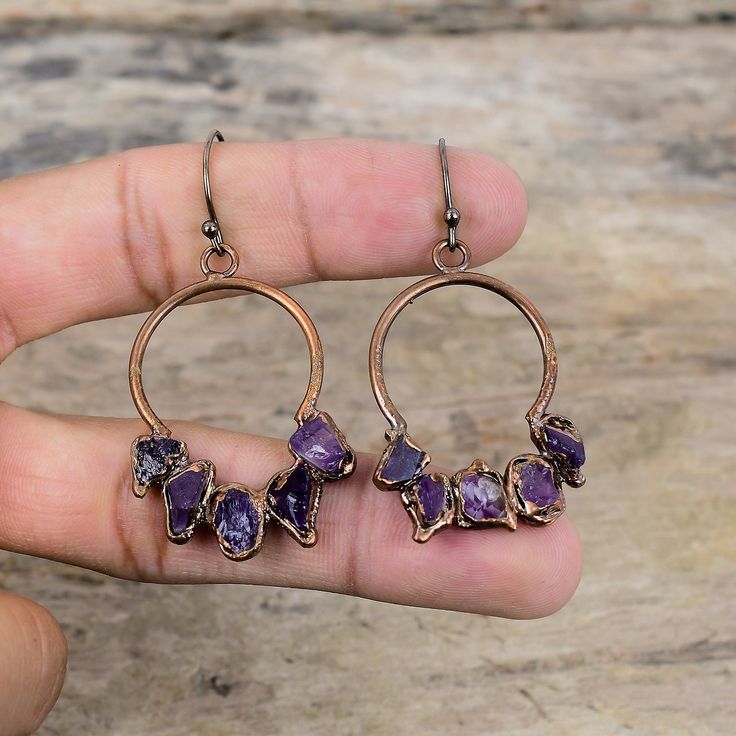 Note : Due to the natural formation of this gemstone. Slight variation in design and color are to be expected.  African Amethyst Rough Earring Electroformed Copper Earring Original Gemstone Jewelry Handmade Earring Electroformed Jewelry Engagement Gift Handmade Electroformed Copper Earrings SKU : VZE-50 Gemstone : African Amethyst Rough Metal Purity : Copper Earrings Length : 60 MM   Earrings Width : 30 MM African amethyst relieves uneasiness, panic, annoyance, restlessness and increases firmness, inner energy and mental strength. African amethyst promotes spiritual awareness and wisdom. African amethyst promotes a higher state of consciousness. Amethyst also provides a wonderful and peaceful energy for meditation. Amethyst Crystal Earrings For Jewelry Making, Amethyst Gemstone Crystal Earrings For Jewelry Making, Purple Earrings With Natural Stones, Wire Wrapped Amethyst Earrings, Round Purple Earrings With Natural Stones, Round Amethyst Earrings With Natural Stones, Luxury Handmade Amethyst Earrings, Amethyst Wire Wrapped Round Earrings, Round Amethyst Gemstone Earrings