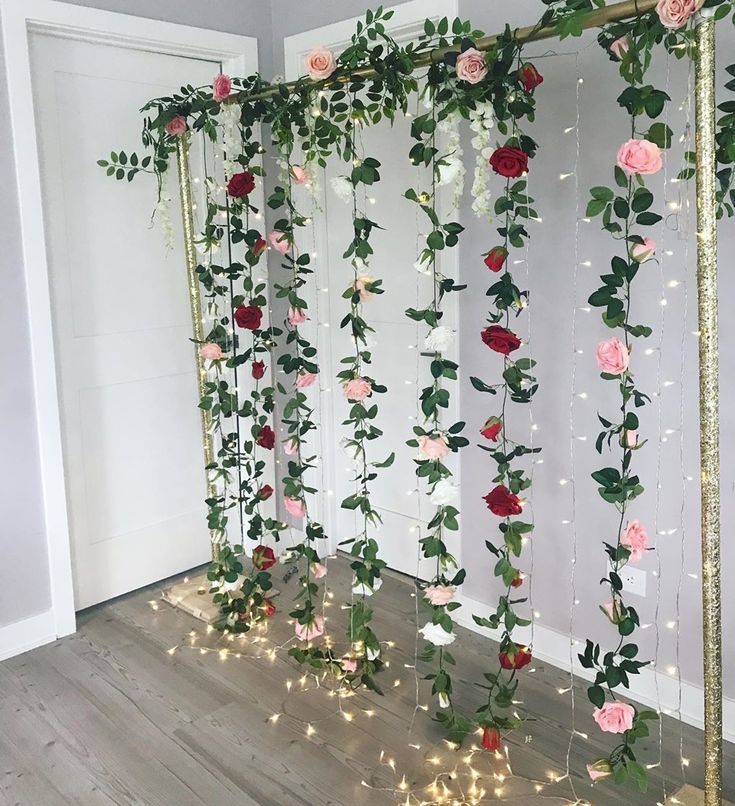 an arrangement of flowers and greenery on a wall