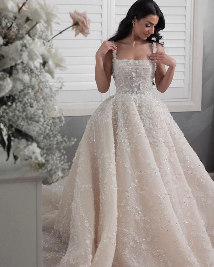 a woman in a wedding dress standing next to flowers