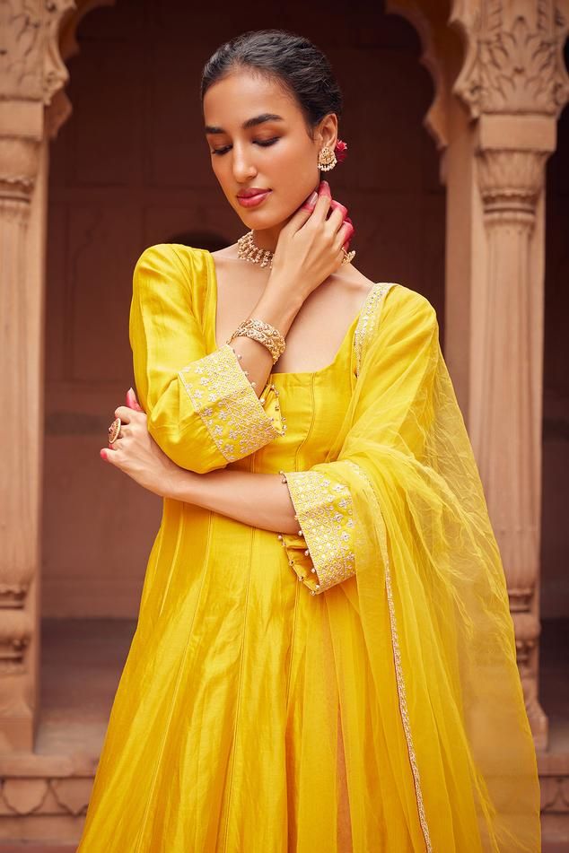 Yellow three fourth sleeves anarkali with floral embroidery on sleeves and kurta hem. Paired with plain churidar and embroidered border dupatta.
Components: 3
Pattern: Embroidery
Type Of Work: Floral
Neckline: Round
Sleeve Type: Three Fourth
Fabric: Chanderi Silk, Tulle
Color: Yellow
Other Details: 
Tassels on dupatta corners
Ghungroo tassels on sleeves hem
Length:
Anarkali: 49 inches
Churidar: 46 inches
Closure:
Anarkali: Back tassel tie-up
Note: The jewellery worn by the model is not for sale Embroidered Anarkali, Types Of Work, Silk Tulle, Embroidered Border, Pattern Embroidery, Churidar, Anarkali, Aza Fashion, Sleeve Type