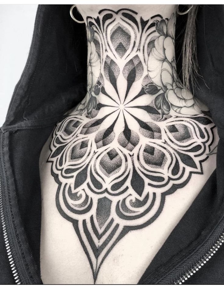 the back of a woman's neck is covered in black and white tattoos,