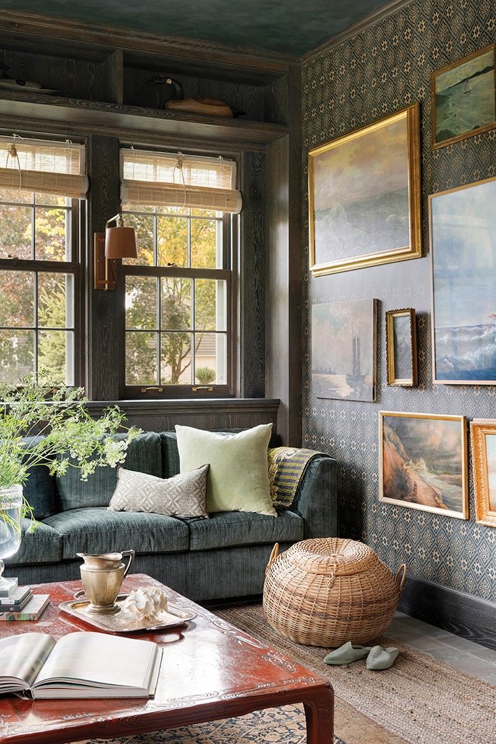 a living room filled with furniture and paintings on the wall above it's windows