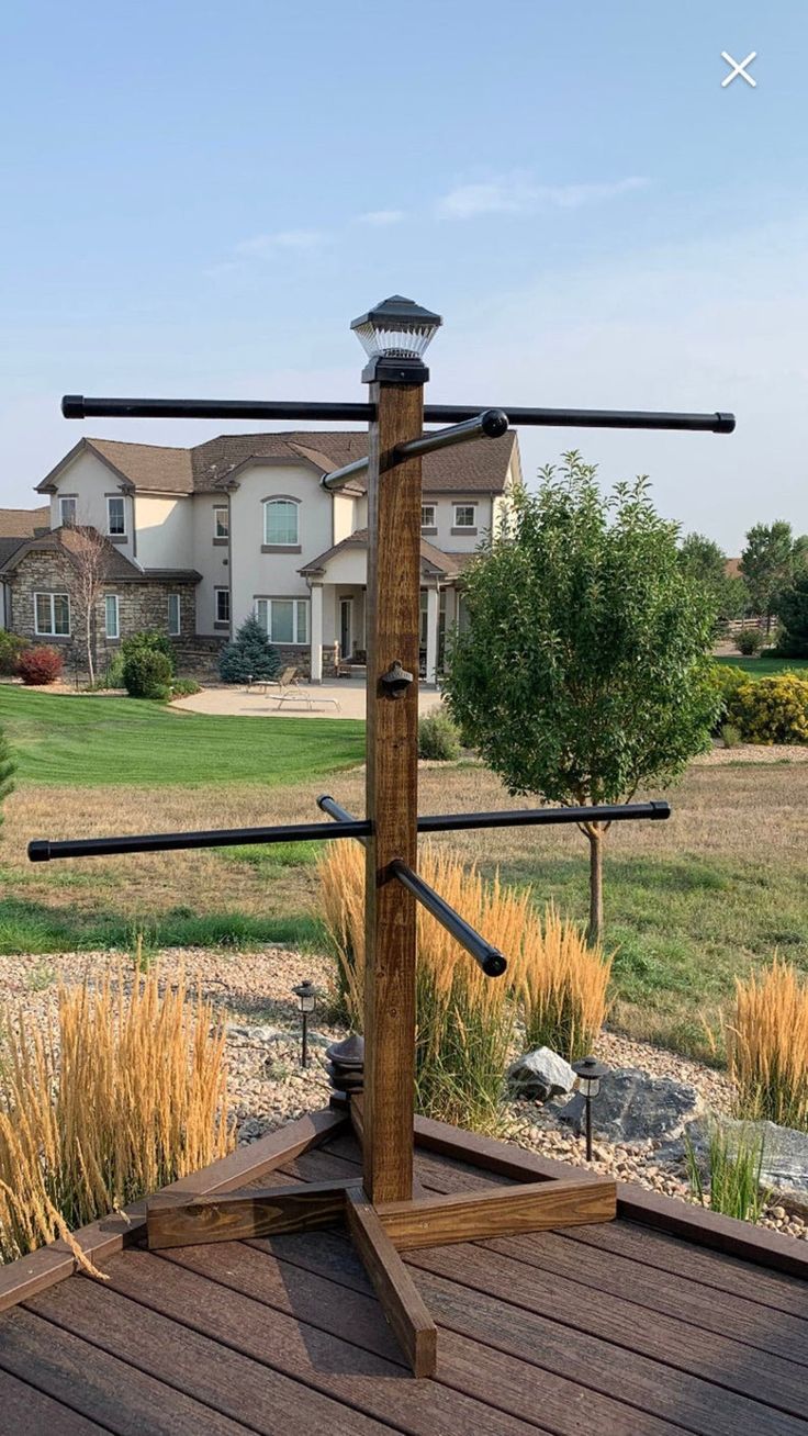 an outdoor gym with two bars on the top and one bar in the middle, near a large house