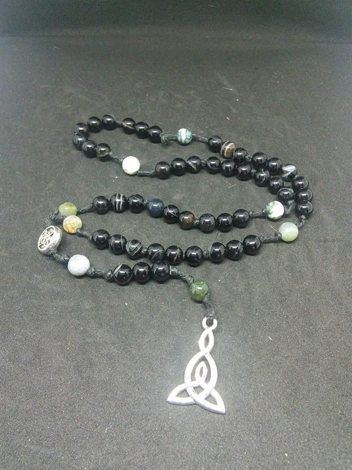 This is a beautiful re-imagined rosary based on the classic Catholic rosary. The beads are evil eye agate and fancy jasper. There are five decades of nine beads each. The center is a Celtic knot, and I have capped it off with a triad pendent. With this rosary I'm including a simple chant which has resonated with me, but feel free to use your own! Pagan/witch prayer chant: Knot one, the work's begun. Knot two, my aim is true. Knot three, it will be. Knot four, power's stored. Knot five, the work' Spiritual Rosary Bracelet With Natural Stones For Meditation, Spiritual Rosary Bracelet With 108 Beads As Gift, Spiritual Rosary Bracelet With Natural Stones For Healing, Spiritual Onyx Beads Jewelry 8mm, Spiritual Rosary Bracelet With Round Beads For Meditation, Spiritual Beaded Rosary As Gift, Spiritual Hand-strung Cross Jewelry, Spiritual Beaded Rosary For Jewelry Making, 108 Bead Cross Jewelry For Meditation