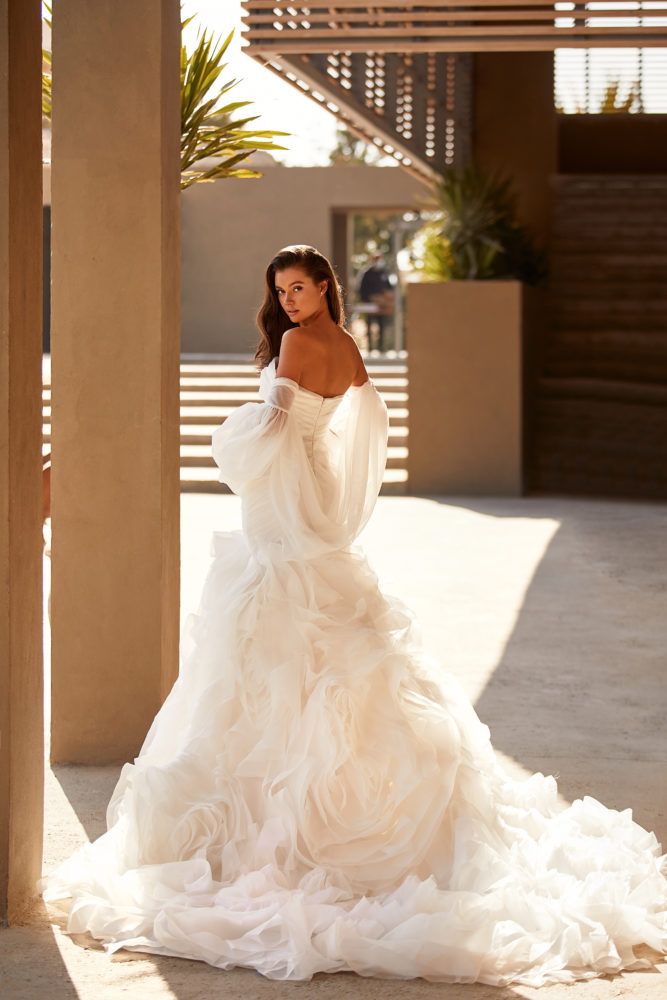 a woman in a wedding dress is standing outside