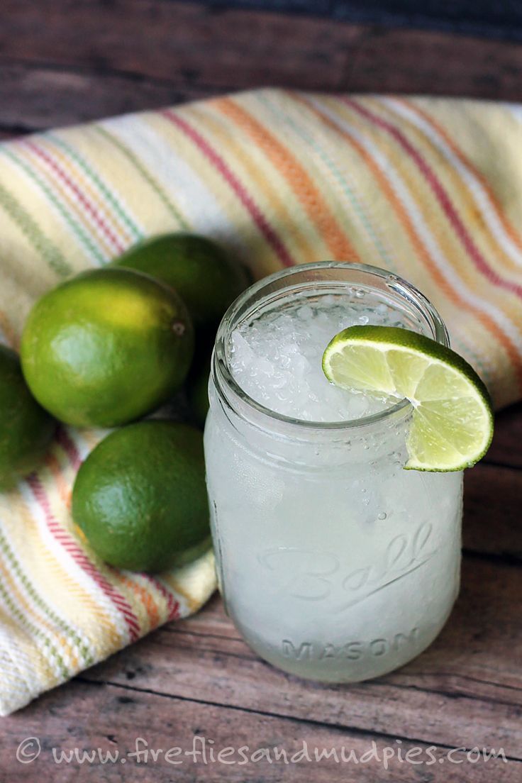 two limes are sitting next to a mason jar