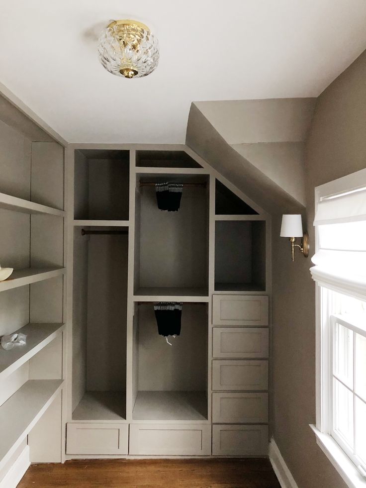 an empty walk in closet with shelves and drawers