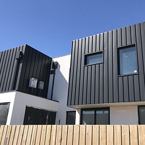 two black and white houses with wooden slats