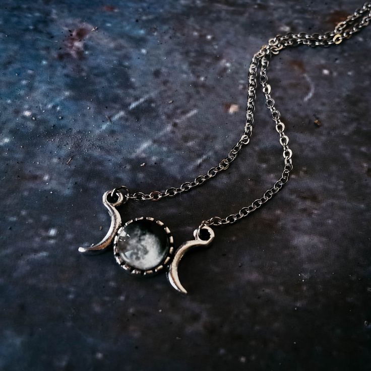 "Personalized and petite, this necklace is the perfect sentimental gift for your favorite stargazer. This pendant has the phase of the moon that was shining in the sky from the date of your choosing (past, present, or future) and is flanked by two crescent moons. Small enough for everyday wear, yet special enough to be treasured. To order, please provide the following information : Date (in this format: MM/DD/YYYY), Time Zone, and Approximate Time Of Day (if possible) of the date you wish to cel Half Moon Metal Necklace For Gift, Half Moon Metal Necklace For Gifts, Metal Moon Phase Charm Necklace As Gift, Mystical Moon Phase Necklace As Gift, Symbolic Metal Necklace With Moon Phase Detail, Adjustable Moon Phase Necklace, Symbolic Moon-shaped Metal Necklace, Symbolic Moon Shaped Metal Necklace, Celestial Metal Necklace With Moon Phase