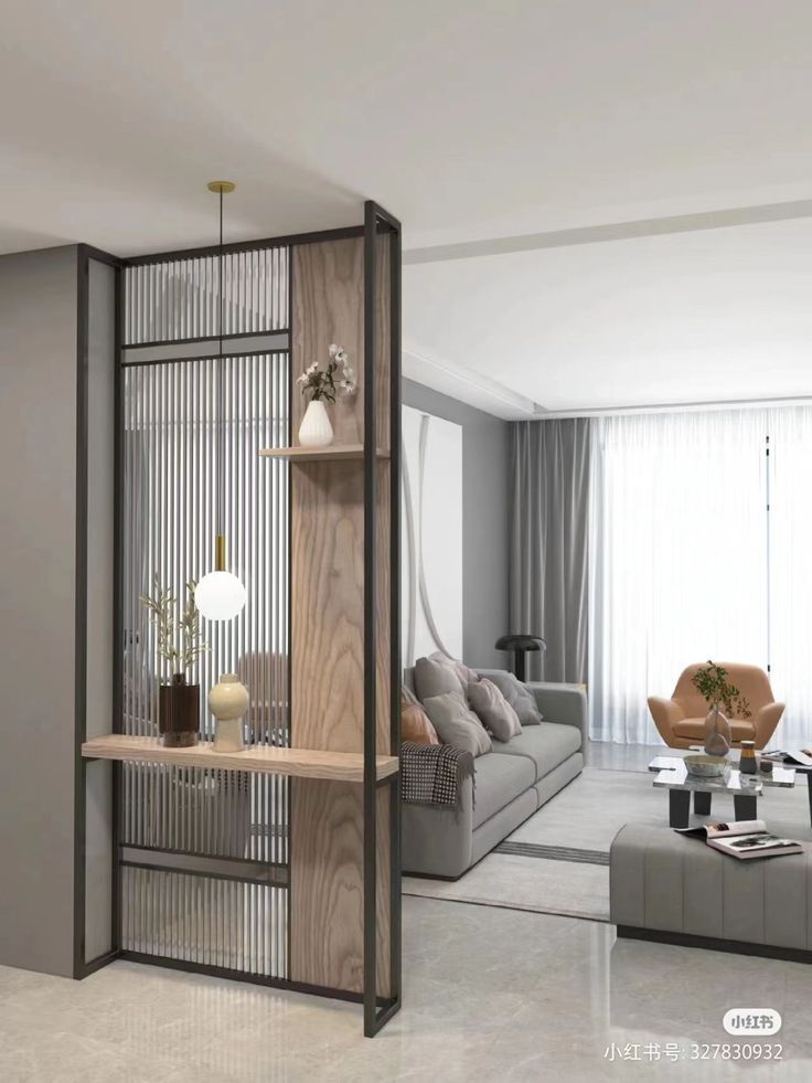 a living room filled with furniture next to a tall glass wall mounted book shelf on top of a hard wood floor