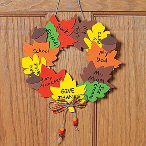 a wreath made out of leaves with the words give thanks written on it hanging from a door