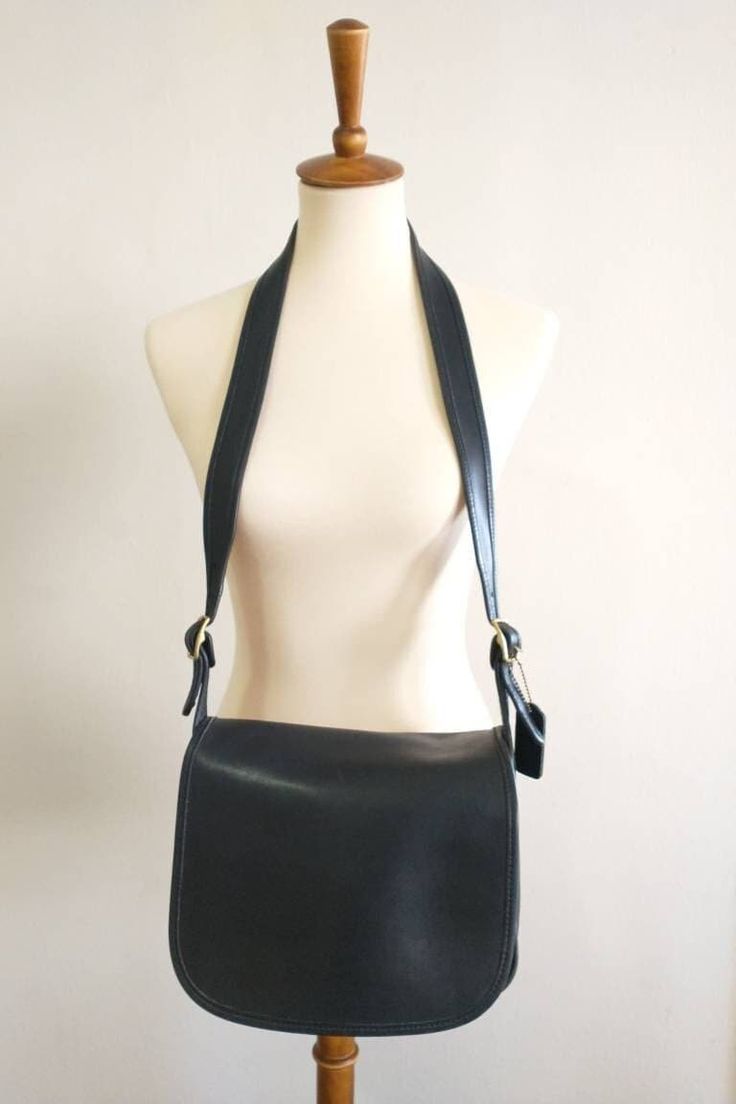 "This beautiful Classic Black Coach shoulder bag has a roomy interior. The inside of the bag has a side pocket with a brass zipper. This does have the Coach creed and although it is faint. There is an extra side pocket which is covered by the flap. This beautiful bag does have the original coach hang tag with brass features. There are scratches on the top flap of the bag and minor piping wear. The straps are adjustable. Over all a really nice bag.  OBO.  Made in Mexico Measurements: Length: 10' Lined Interior Satchel Bag, Classic Travel Shoulder Bag With Lined Interior, Classic Bags For Daily Use With Lined Interior, Elegant Rectangular Shoulder Bag With Lined Interior, Formal Rectangular Bag With Lined Interior, Formal Tote Bag With Lined Interior, Classic Leather Shoulder Bag With Lined Interior, Classic Shoulder Bag With Lined Interior For Daily Use, Elegant Leather Shoulder Bag With Lined Interior