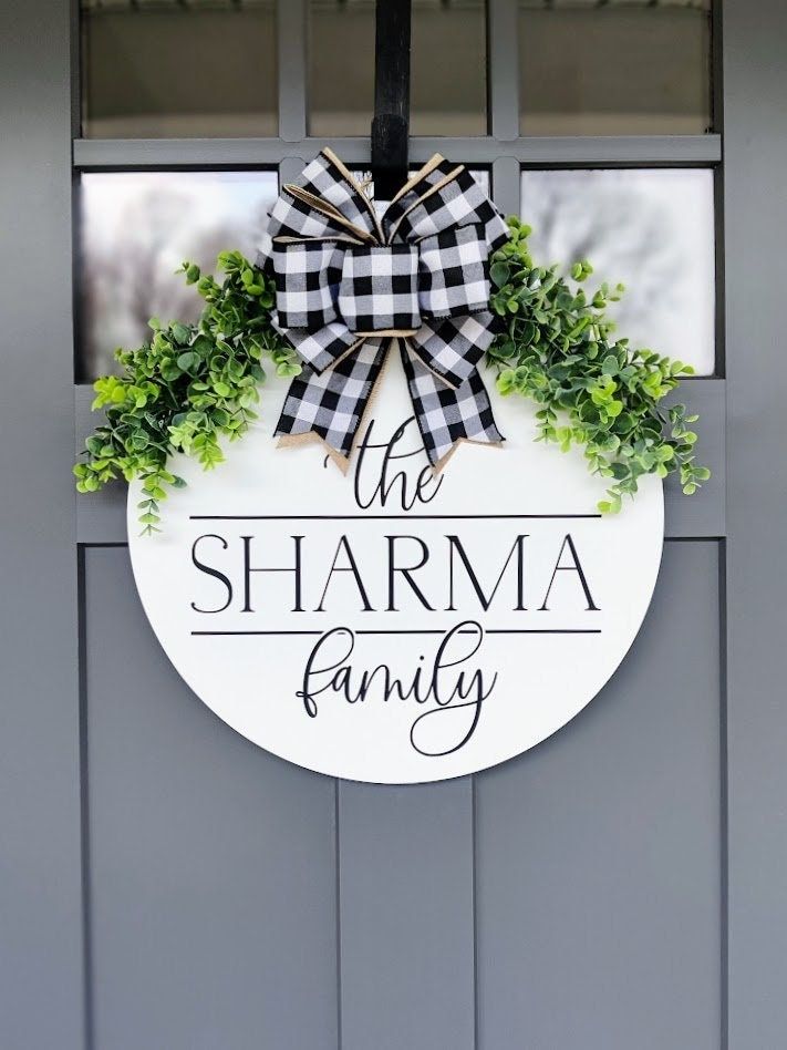 a door hanger that says, the charma family with a bow on it