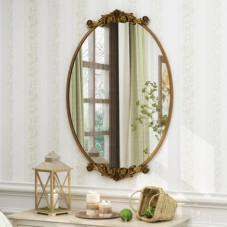 a mirror sitting on top of a dresser next to a table with a basket and candle