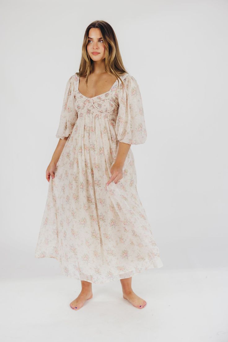 This gorgeous dress is a *vibe* and we are here for it. If you think the Harlow is stunning in photos, wait till you see it in person - this dress will make a statement wherever you go! It features incredible puffed sleeves, a bustier-style structured bodice, and a voluminous skirt. This floral gem is extra-luxe, and 100% the choice when you're looking to stand out from the crowd. Pair it with a glam set of pumps for a night at the symphony, or with heeled sandals for a baby shower - just prepar Spring Mid-length Maxi Dress With Fitted Bodice, Bohemian Floral Print Dress With Empire Waist, Flowy Smocked Bodice Midi Dress, Bohemian Fitted Dress With Sweetheart Neckline, Beach Dress With Floral Print And Fitted Bodice, Feminine Beach Dress With Fitted Bodice, Daywear Floral Empire Waist Dresses, Feminine Fitted Bodice Dress For Beach, Floral Print Empire Waist Day Dresses