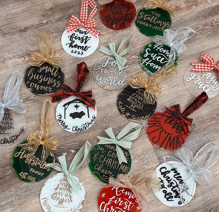 six christmas ornaments are on a table with bows and tags attached to each ornament