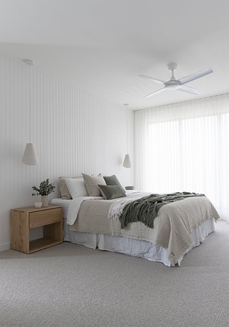 a bedroom with white walls and carpeted flooring has a bed in the middle