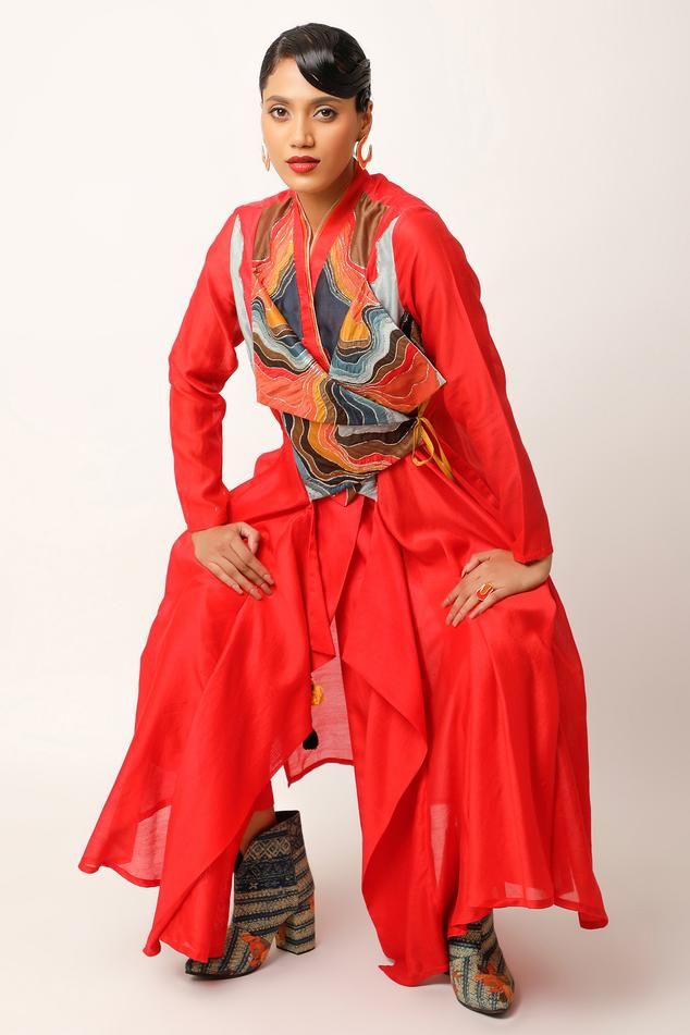 Red angarkha with asymmetric draped panels, landscape pattern yoke, overlap pointed hem panels, multi color patch, zari and thread embroidery. Paired with straight fit pant.
Components: 2
Pattern: Embroidered and Printed
Type Of Work: Applique, Thread and Zari Work
Neckline: Lapel Collar
Sleeve Type: Full Sleeves
Fabric: Silk Chanderi, Cotton Slub
Color: Red
Other Details: 
Fringe drop tassels
Side elasticated waist
Back inverted pleated detail
Length:
Angarkha: 50 inches
Pant: 35 inches
Angarkh Red Bandhgala With Dabka For Designer Wear, Red Long Sleeve Bandhgala For Designer Wear, Red Designer Nehru Jacket For Festive Occasions, Red Palazzo Set For Party, Red Long Sleeve Bandhgala For Diwali, Red Nehru Jacket For Festive Designer Wear, Red Nehru Jacket For Festive Transitional Season, Red Festive Nehru Jacket For Transitional Season, Traditional Red Bandhgala With Long Sleeves