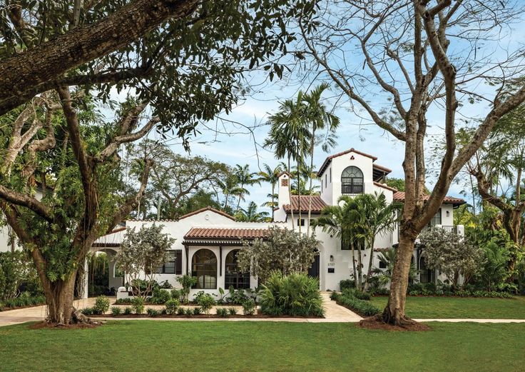 a large white house surrounded by trees and grass