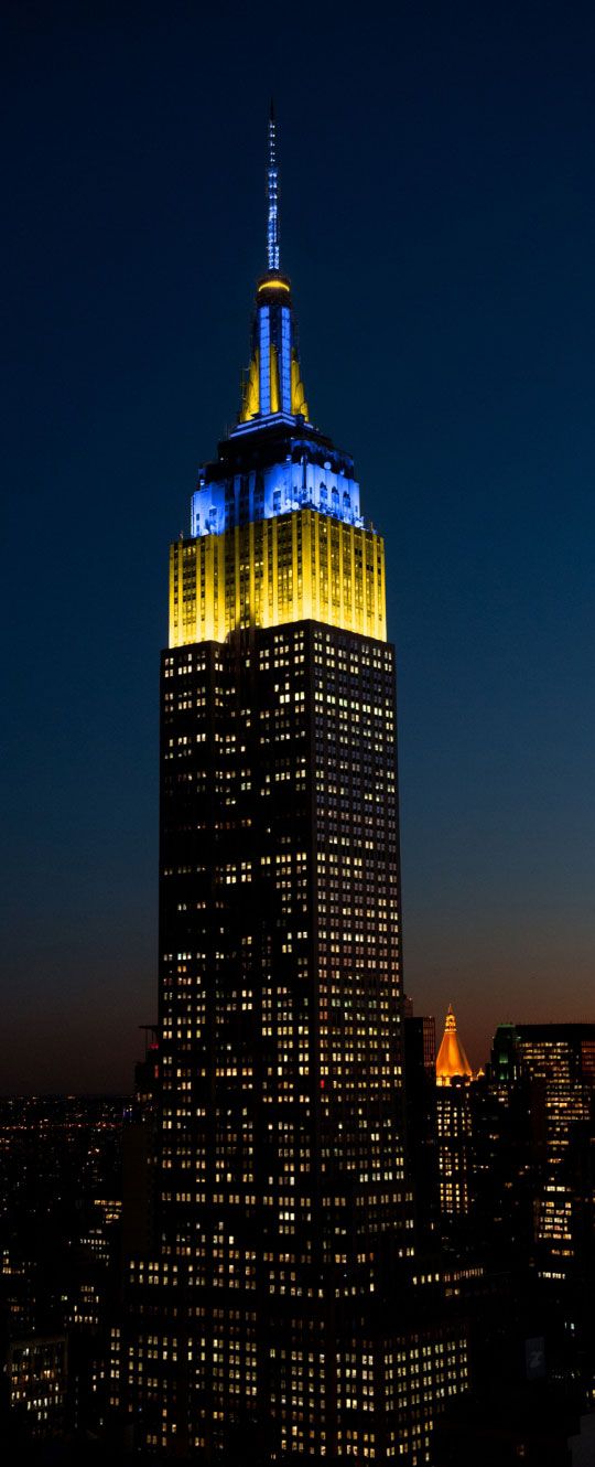 the empire building lit up in blue and white