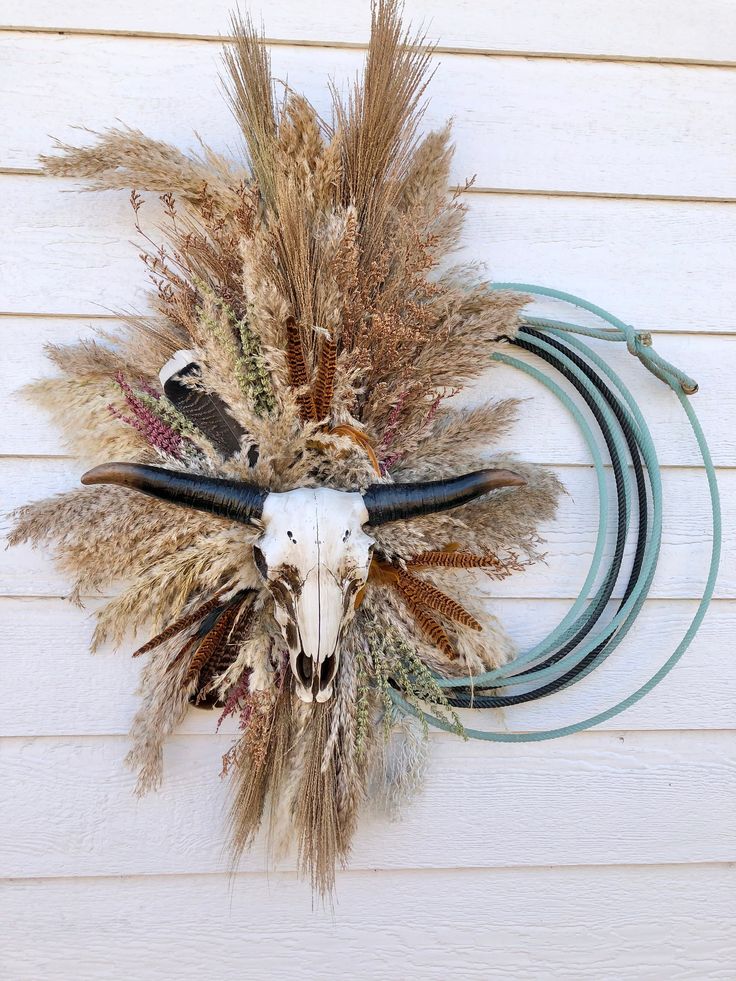 Elevate your home decor with our rope wreath, a stunning piece of western wall art featuring an Aztec cow skull design. This lasso wreath adds a rustic touch to any farmhouse decor, perfect for enhancing your living room with a unique western longhorn sign. KEY FEATURES *Approximate Dimensions: 1.38" H x 19.63" W x 4.31" D* Bull Head  * Choose your florals  RUSH MY SHIPPING USE THIS LINK! https://jamesonropeandco.etsy.com/listing/1691702946/rush-my-shipping CUSTOMIZE MY WREATH  https://jamesonro Dining Room Western Decor, Ranch Room Decor, Lasso Rope Decor, Western Christmas Wreaths, Boho Western Office Decor, Western Boho Office Decor Ideas, Rope Wreath Diy Western, Western Rope Crafts, Western Fall Decor Ideas