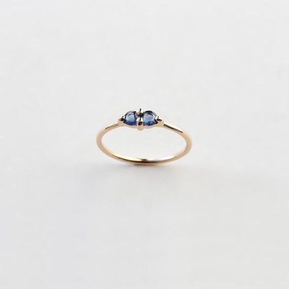 Yellow gold ring with two natural blue sapphires set in thick prongs. A couple of sapphires signifying the unity of two.The number of prongs was reduced for a minimal and elegant look. This sapphire ring works great both as a subtle elegant engagement ring or an upgraded wedding band. The low profile setting makes it ideal for everyday wear. Available in 9k & 18k yellow gold.Sapphires: 3.25mm, 0.28ct total, deep blue, ethically sourcedBand Width: 1.3mm, recycled goldCan't find your size? Loo Elegant Engagement Ring, Sapphire Solitaire Ring, Elegant Engagement Rings, Sapphire Solitaire, Oxidised Jewellery, Blue Band, Natural Blue Sapphire, Recycled Gold, Yellow Gold Ring